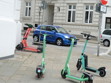Auf dem Bild sind vier E-Scooter zu sehen an einer Straßenecke.