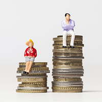 Das Bild zeigt zwei Miniaturfiguren, die auf gestapelten Münzen sitzen. Die linke Figur trägt eine rote Jacke und einen gelben Hut und sitzt auf einem kleineren Stapel Münzen. Die rechte Figur trägt ein lila Oberteil und weiße Hosen und sitzt auf einem höheren Stapel Münzen. Der Hintergrund ist schlicht und weiß.