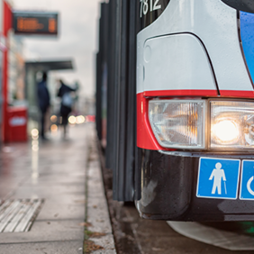 Auf dem Bild hält grade ein Bus des ÖPNV an einer Bushaltestellt. Abgebildert sich die Symbole für Senioren und Rollstuhlfahrer.