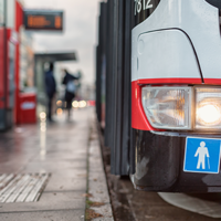 Auf dem Bild hält grade ein Bus des ÖPNV an einer Bushaltestellt. Abgebildert sich die Symbole für Senioren und Rollstuhlfahrer.