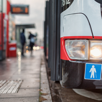 Auf dem Bild hält grade ein Bus des ÖPNV an einer Bushaltestellt. Abgebildert sich die Symbole für Senioren und Rollstuhlfahrer.