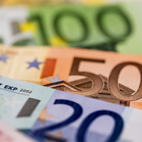 Das Bild zeigt eine Nahaufnahme von mehreren Euro-Banknoten, die teilweise übereinander liegen. Zu sehen sind Banknoten im Wert von 100, 50 und 20 Euro. 