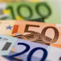 Das Bild zeigt eine Nahaufnahme von mehreren Euro-Banknoten, die teilweise übereinander liegen. Zu sehen sind Banknoten im Wert von 100, 50 und 20 Euro. 
