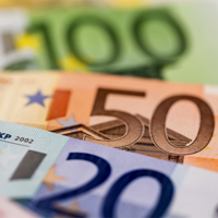 Das Bild zeigt eine Nahaufnahme von mehreren Euro-Banknoten, die teilweise übereinander liegen. Zu sehen sind Banknoten im Wert von 100, 50 und 20 Euro. 