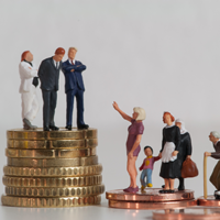 Auf der linken Seite stehen drei Miniaturfiguren in formeller Kleidung auf einem hohen Stapel von Münzen, was Wohlstand und Macht repräsentiert. Auf der rechten Seite befinden sich mehrere Miniaturfiguren, darunter eine Frau mit einem Kind, eine ältere Frau mit einer Einkaufstasche und ein Mann im Rollstuhl, die auf niedrigeren Münzstapeln stehen. 